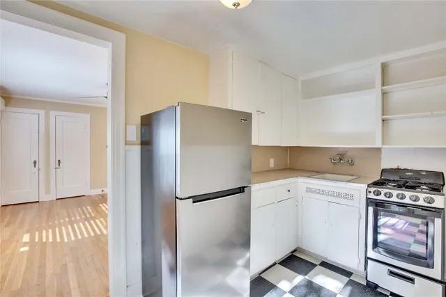a kitchen with a refrigerator and a stove top oven