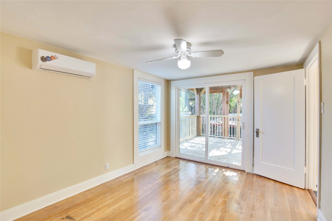 1115 Enfield Road, Unit C Austin, TX 78703 - Photo 9 of 26 a view of an empty room with wooden floor and a window