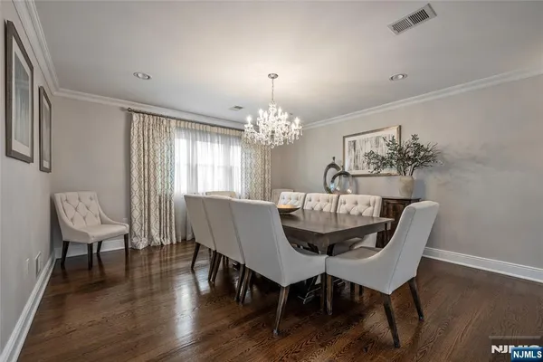 a dining room with furniture a chandelier and wooden floor