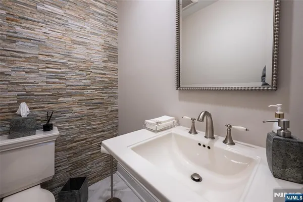 a bathroom with a sink a toilet and mirror