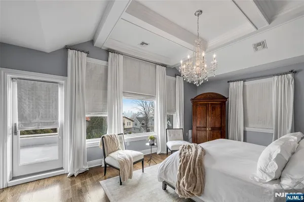 a bedroom with a bed and a chandelier