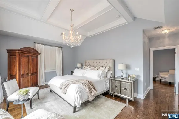 a bedroom with a bed and a chandelier