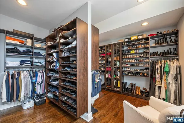 a view of walk in closet with clothes and shoes