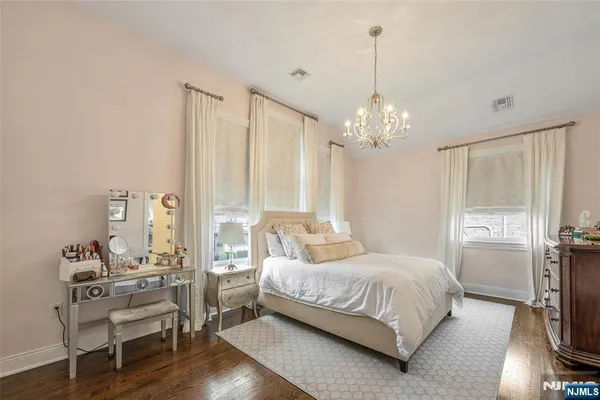a bedroom with a bed chandelier and a window