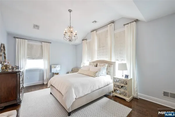 a bedroom with a large bed and a chandelier
