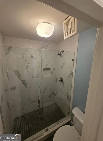 a bathroom with a granite countertop toilet sink and shower