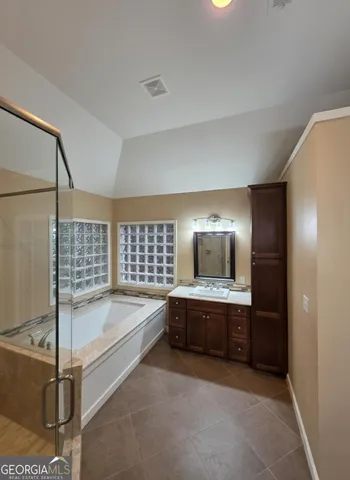 a spacious bathroom with sink shower and bathtub