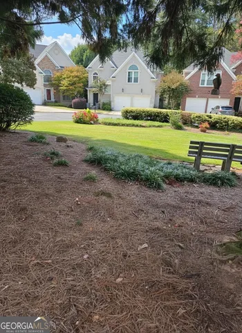 a view of a house with a yard and sitting area