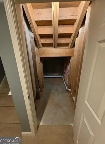 a view of staircase with railing and white walls