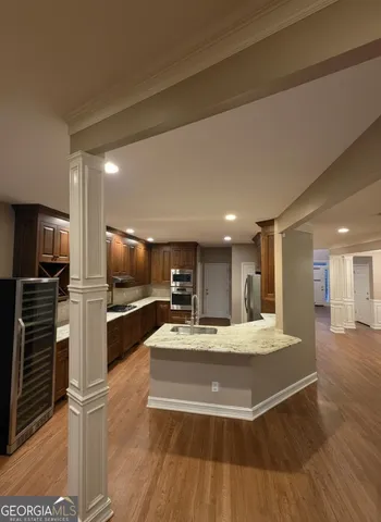 a large kitchen with kitchen island a large counter top stainless steel appliances and cabinets