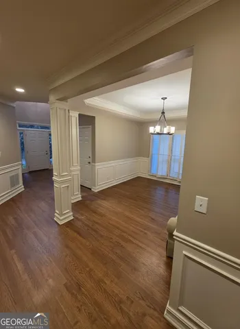 a view of empty room with wooden floor