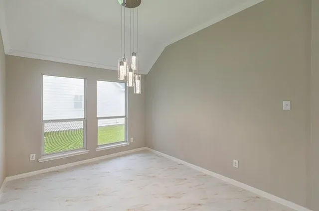 an empty room with windows and chandelier fan