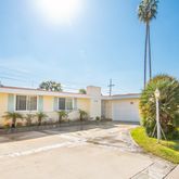 a front view of a house with a garden and plants