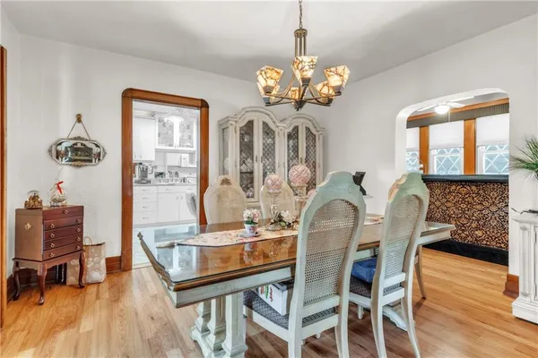 a dining room with furniture a chandelier and wooden floor