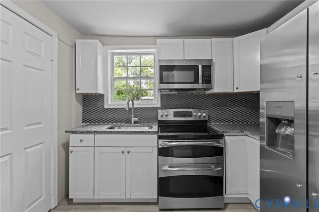a kitchen with white cabinets and appliances