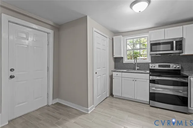 a kitchen with granite countertop a refrigerator and a stove top oven