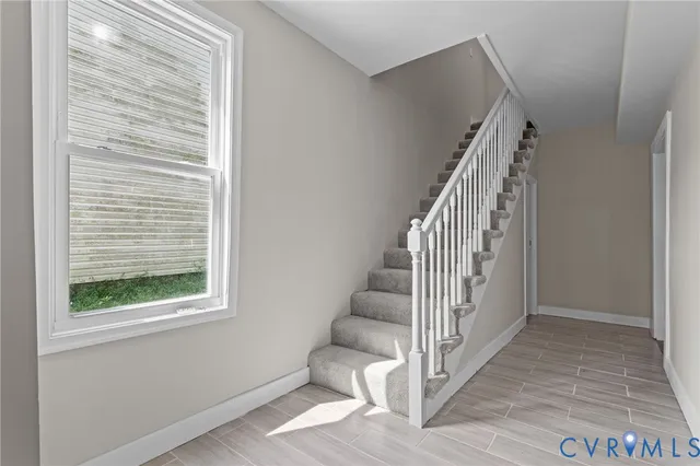 a view of a hallway with wooden floor and entryway