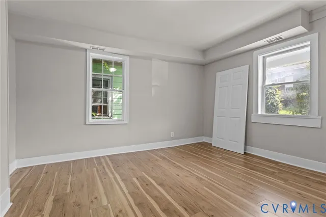 wooden floor in an empty room with a window