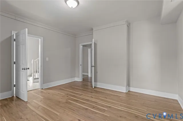 a view of an empty room with wooden floor