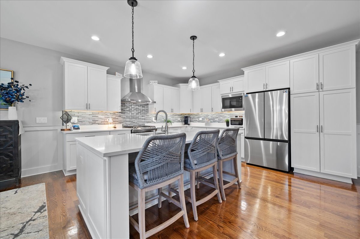 1383 Dodson Avenue Elburn, IL 60119 - Photo 6 of 25 a kitchen with stainless steel appliances granite countertop a refrigerator a sink dishwasher a stove a dining table and chairs with wooden floor