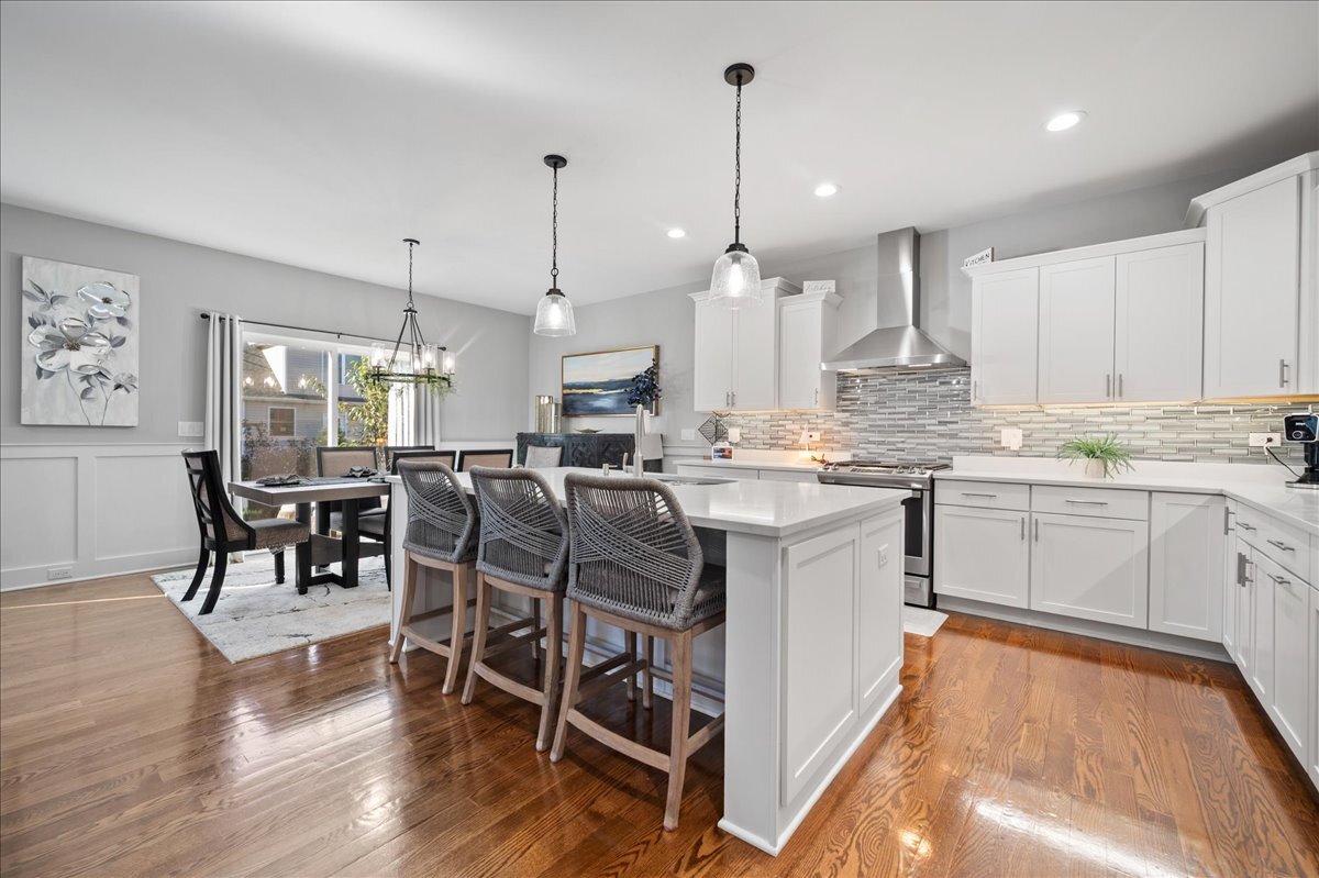 1383 Dodson Avenue Elburn, IL 60119 - Photo 7 of 25 a kitchen with stainless steel appliances kitchen island granite countertop a table chairs and a wooden floor