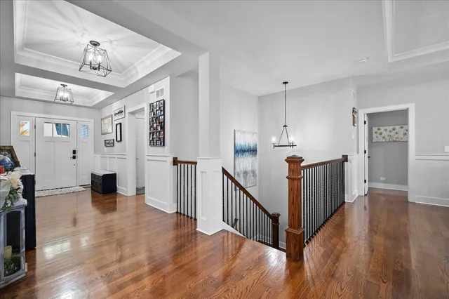 a view of a hallway with wooden floor and staircase