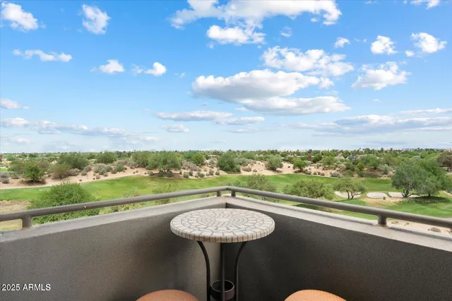a view of a city from a balcony with furniture