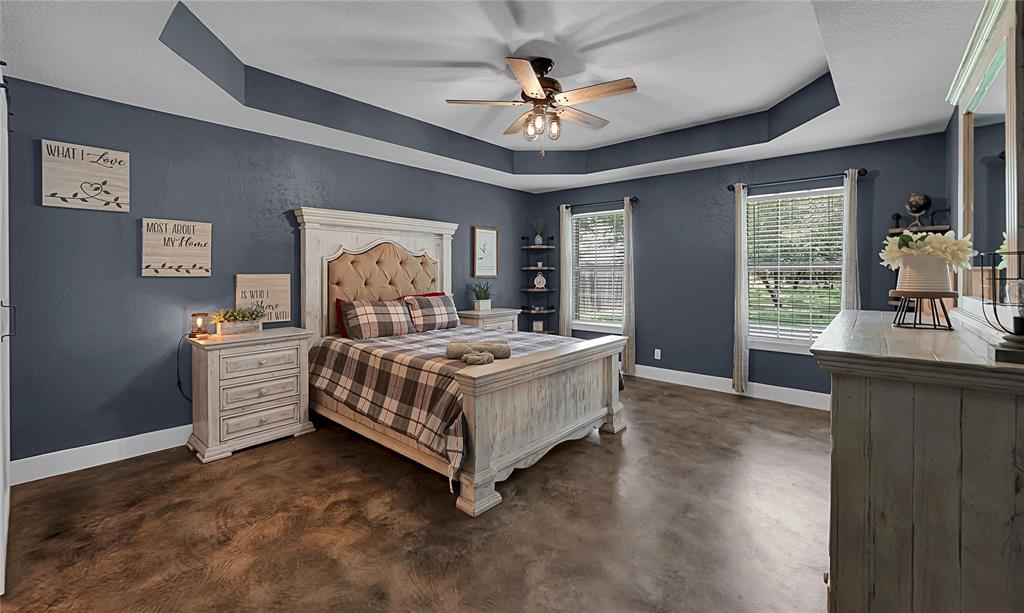 37 Bluebonnet Loop Morgan's Point Resort, TX 76513 - Photo 16 of 38 Spacious bedroom featuring a tray ceiling with a ceiling fan, two large windows with blinds, wood-finish flooring, and built-in corner shelving