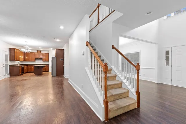 a view of a hallway with wooden floor and staircase