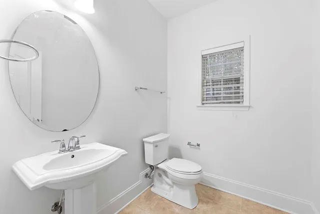 a bathroom with a toilet a sink and a mirror