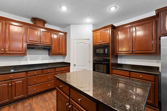 a kitchen with stainless steel appliances granite countertop a sink and cabinets