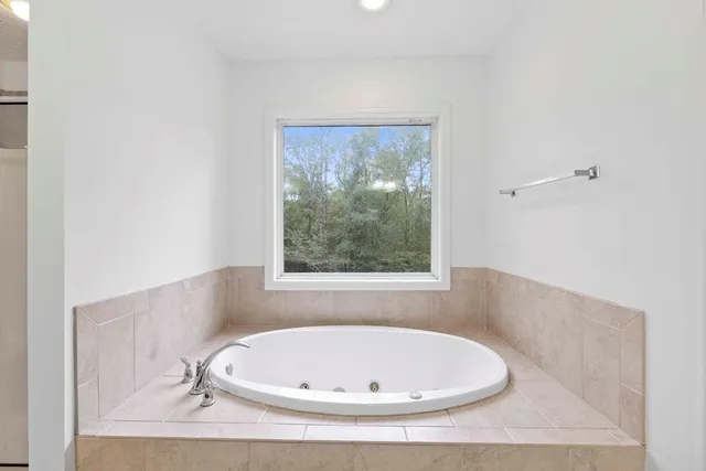 a white bath tub sitting in a bathroom next to a window