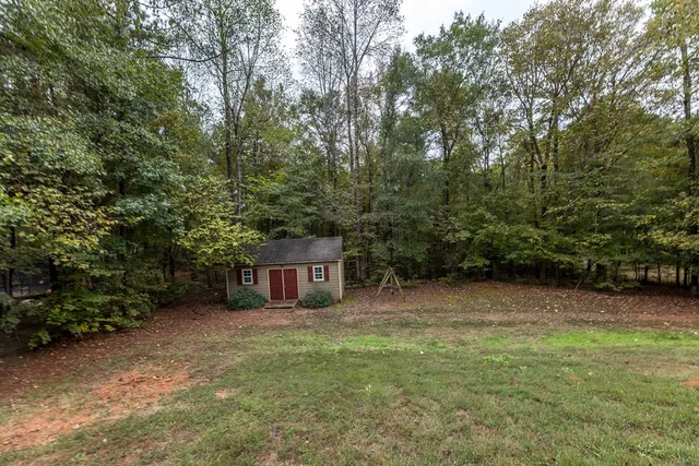 a view of house with outdoor space and trees