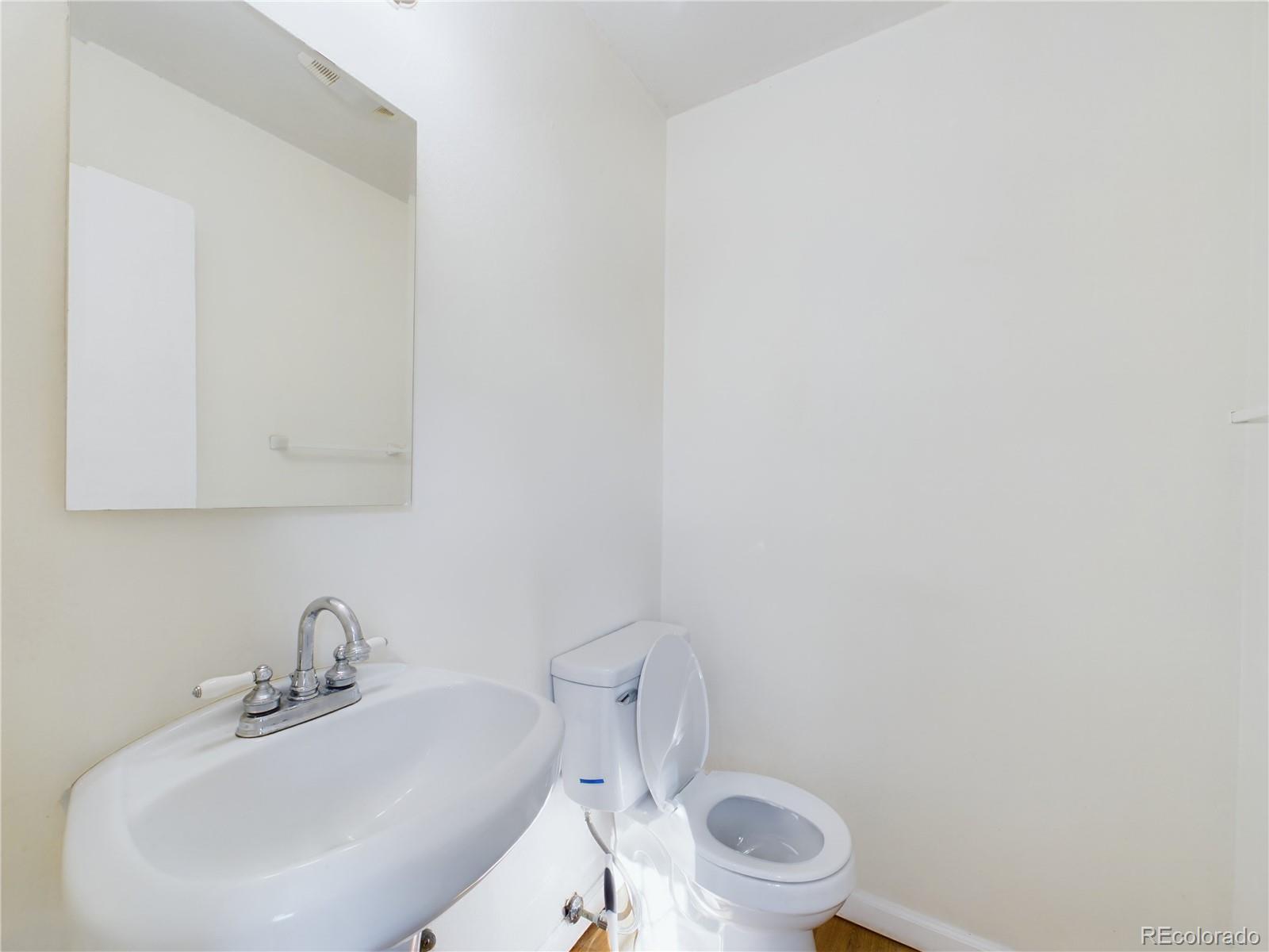 8770 Rainbow Avenue, Unit B4 Denver, CO 80229 - Photo 12 of 29 a bathroom with a toilet a sink and mirror