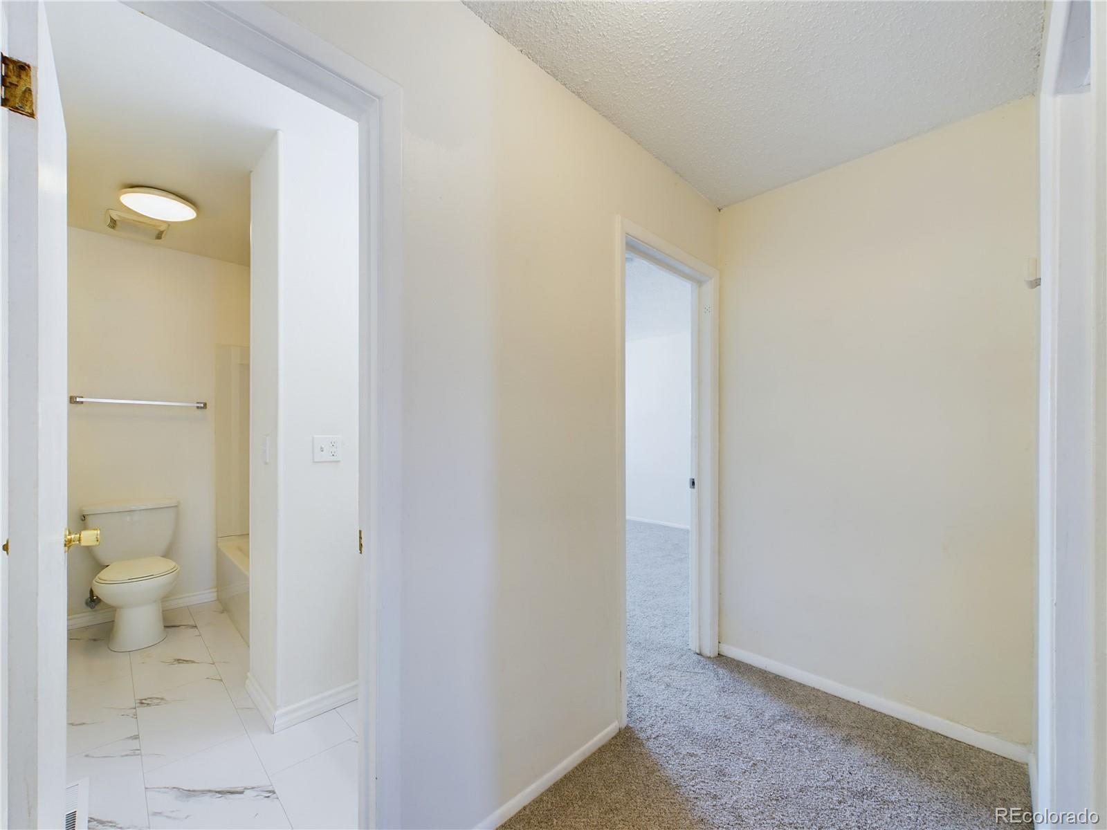 8770 Rainbow Avenue, Unit B4 Denver, CO 80229 - Photo 15 of 29 a bathroom with a granite countertop toilet and a shower