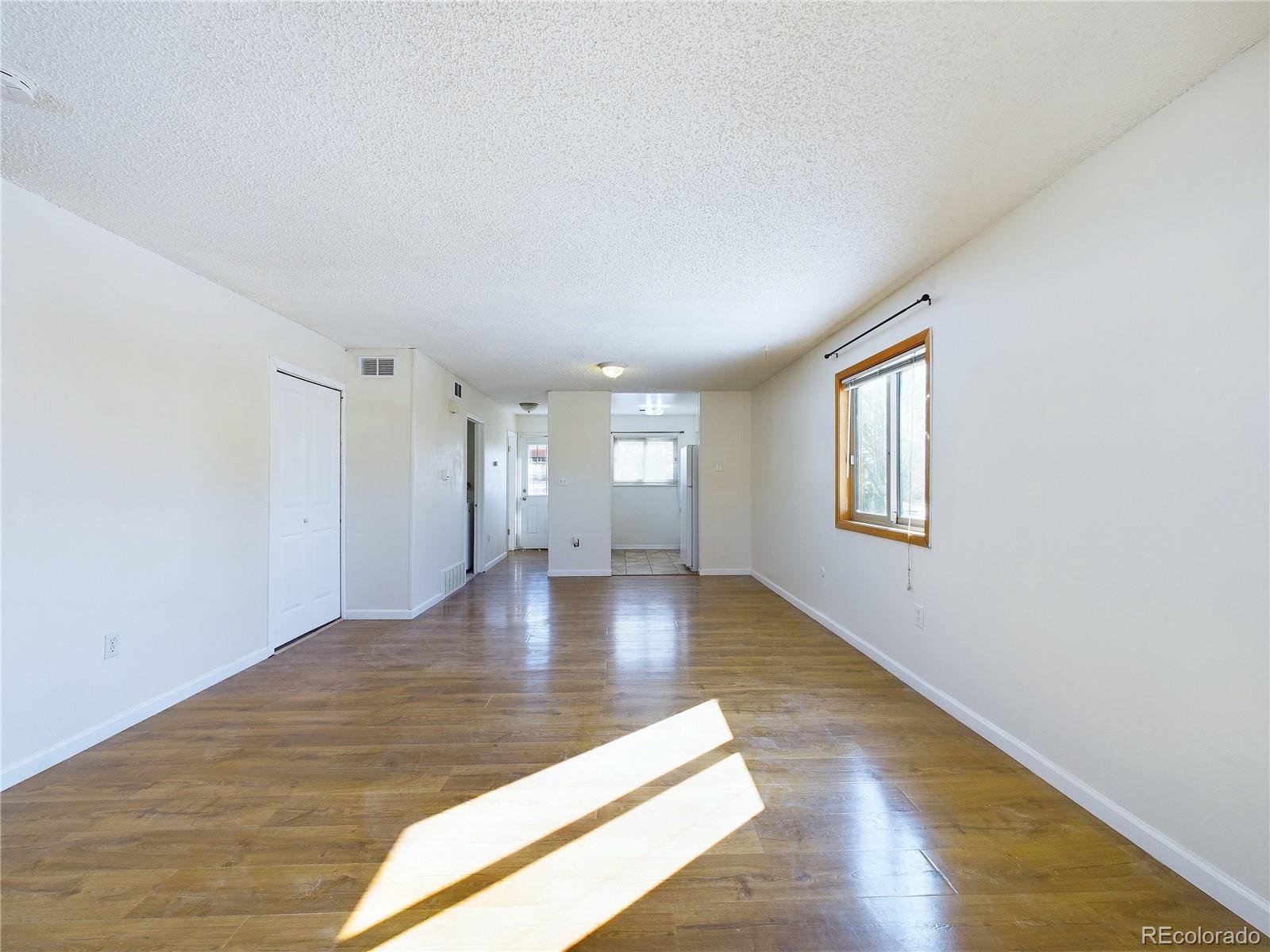 8770 Rainbow Avenue, Unit B4 Denver, CO 80229 - Photo 6 of 29 a view of an empty room with window and wooden floor