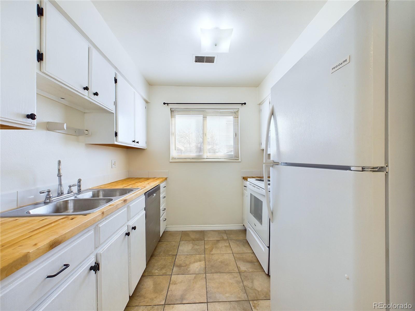 8770 Rainbow Avenue, Unit B4 Denver, CO 80229 - Photo 7 of 29 a kitchen with a sink stove and refrigerator