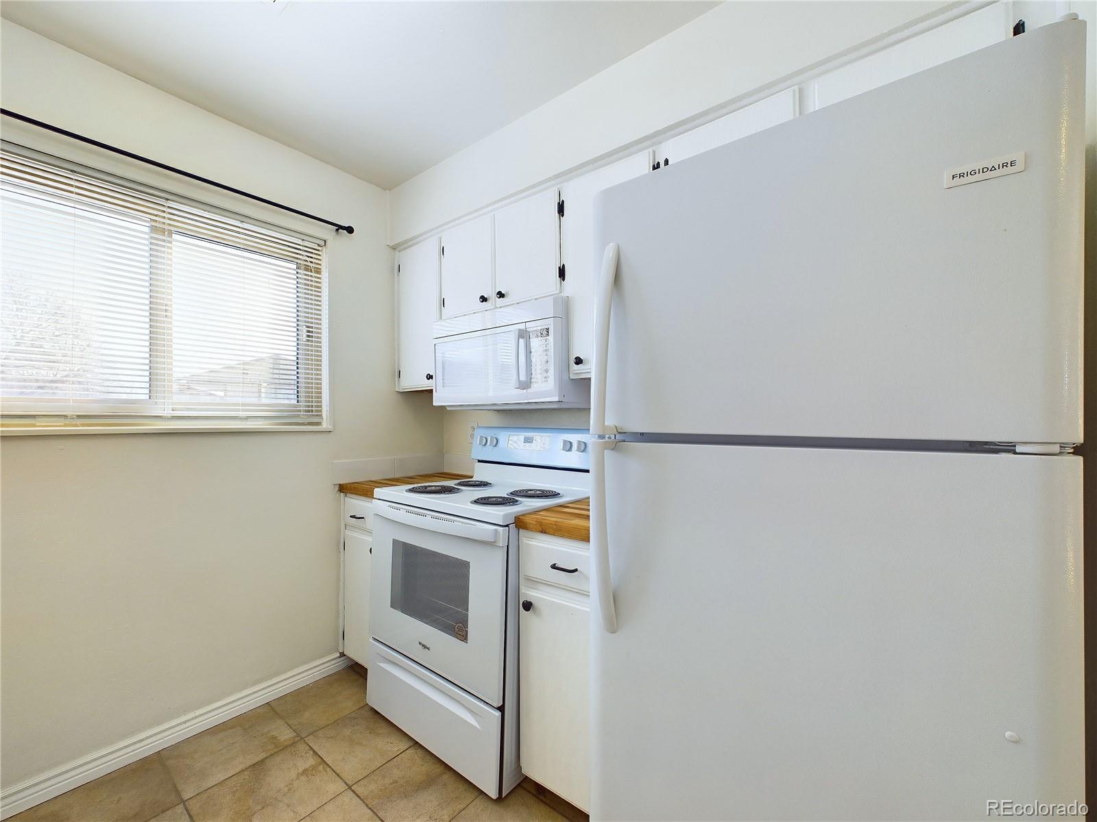 8770 Rainbow Avenue, Unit B4 Denver, CO 80229 - Photo 9 of 29 a kitchen with a stove a sink and a refrigerator