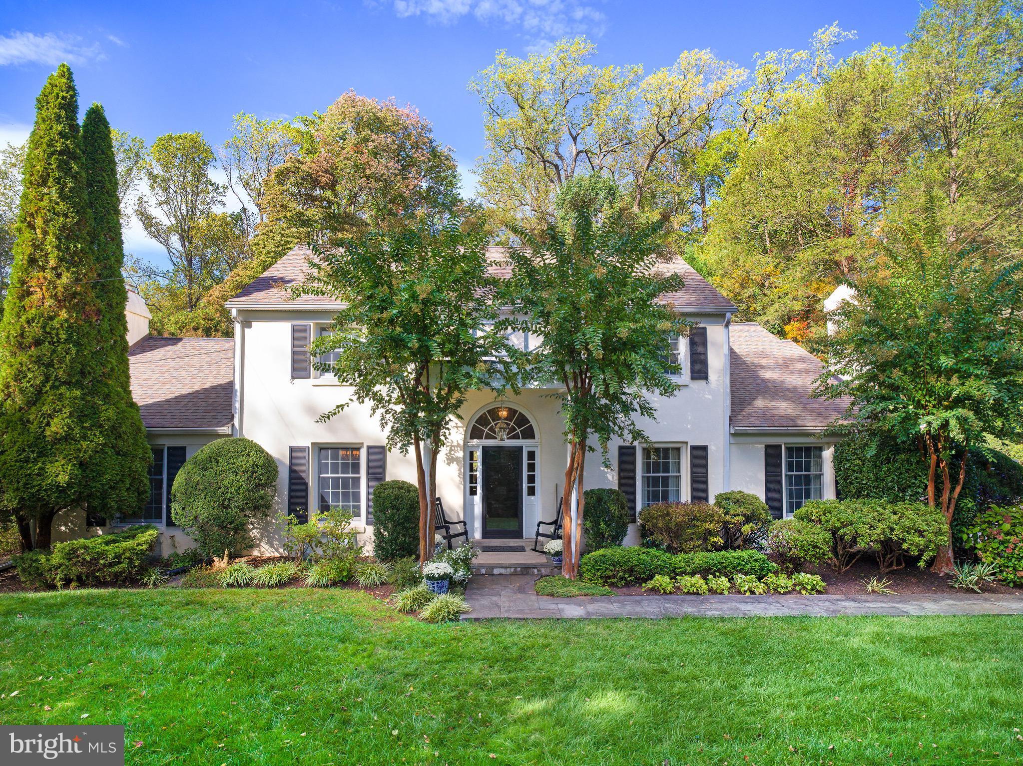 a front view of a house with a yard and trees