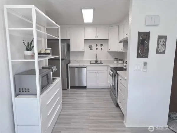 a kitchen with cabinets and stainless steel appliances