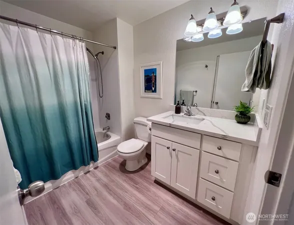 a bathroom with a granite countertop sink toilet and shower view