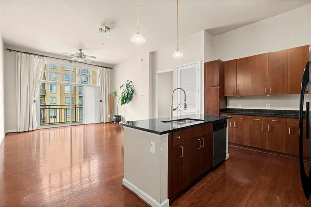 a large kitchen with stainless steel appliances granite countertop a stove and a wooden floors