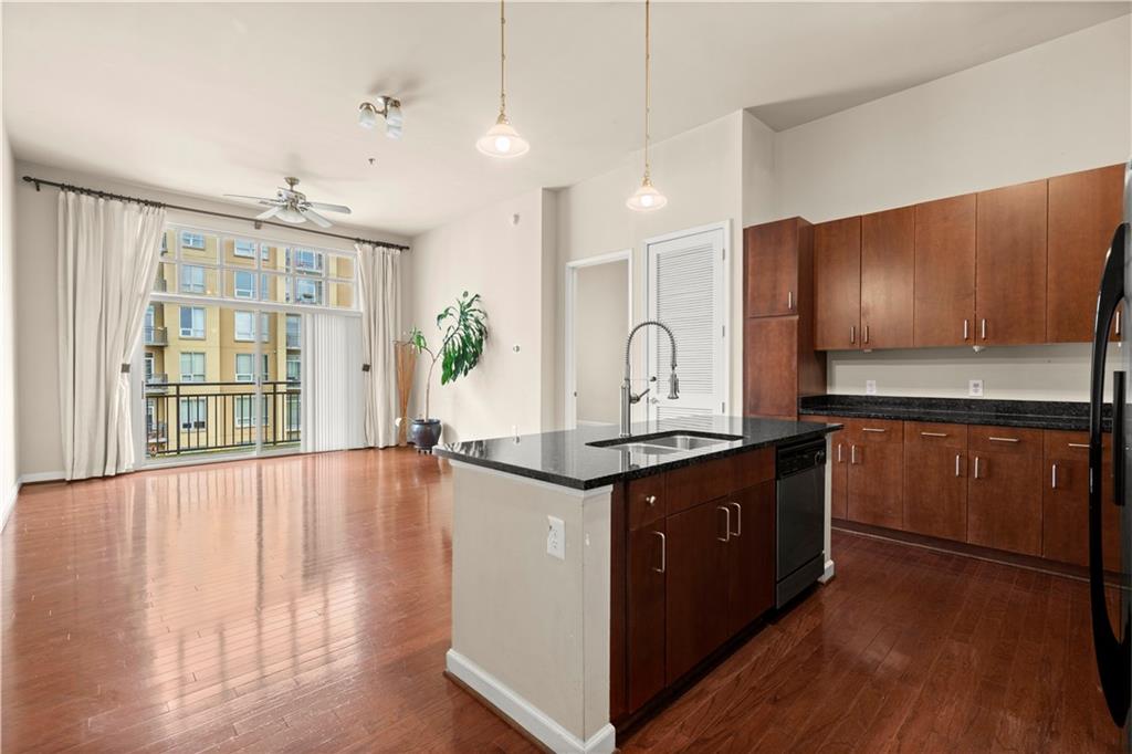 a large kitchen with stainless steel appliances granite countertop a stove and a wooden floors