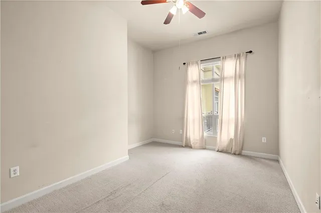 an empty room with closet and a chandelier fan