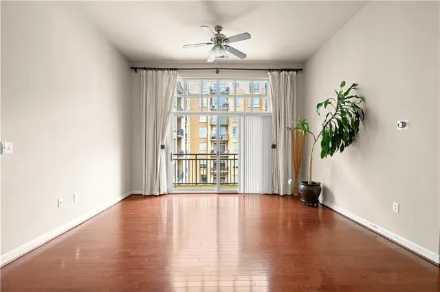 a view of an empty room with a window and wooden floor