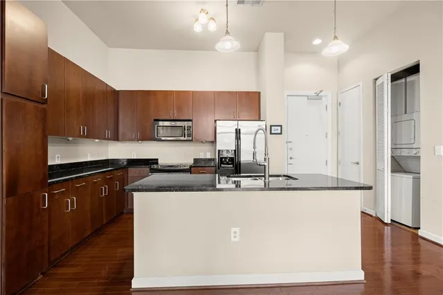 a kitchen with kitchen island granite countertop a sink and refrigerator