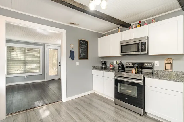 a kitchen with stainless steel appliances granite countertop a stove a microwave and a refrigerator