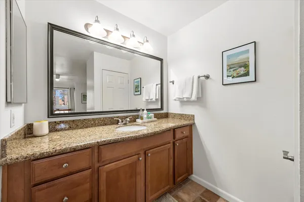 a bathroom with a granite countertop double vanity sink and a mirror