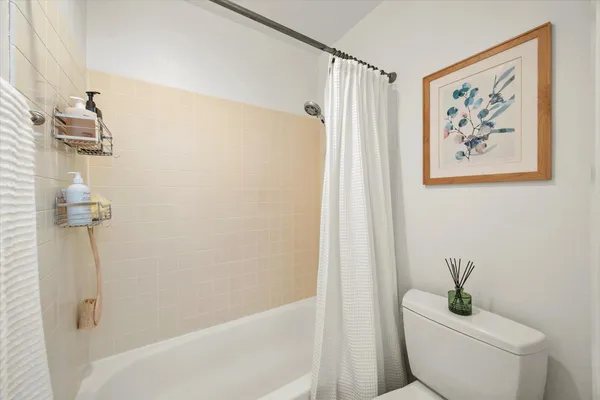 a white toilet sitting next to a bath tub