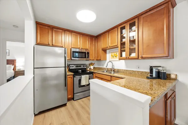 a kitchen with granite countertop stainless steel appliances a refrigerator stove microwave and sink